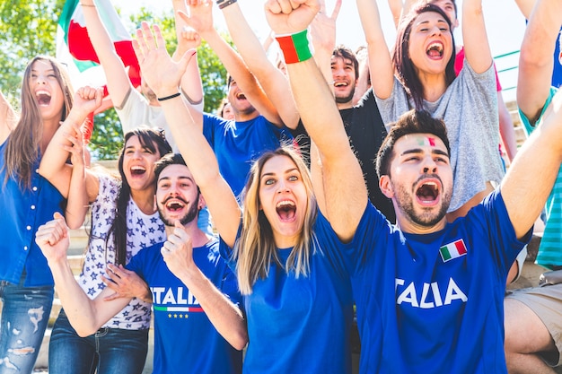 Adeptos italianos comemorando no estádio com bandeiras