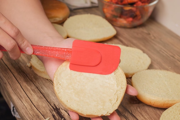 Aderezo para untar a mano en rebanadas de pan de hamburguesa delicioso con color dorado y cocinado en casa