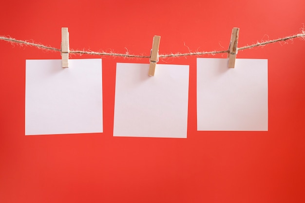 Adesivos de lembrete brancos sobre um fundo vermelho. folhas de papel em branco para desejos e objetivos.