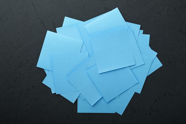 Adesivos de papel azul em fundo preto Notas autoadesivas em branco com espaço de cópia pronto para sua mensagem Objetivos de ano novo ou conceito de resoluções Idéia de segunda-feira azul Espaço de cópia plano leigo em fundo preto