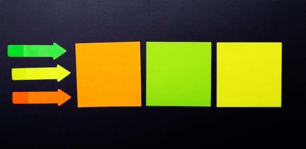 Adesivos de papel transparente sortido multicolorido brilhante em uma parede preta. copiar localização