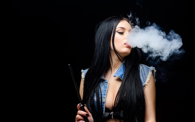 Adicción poco saludable Tabaco droga exhalar humo sobre fondo negro Mal hábito Mujer vapor mujer sexy fumar cigarro barra de narguile Cigarrillo electrónico copia espacio sentirse libre