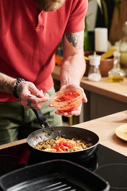 Adicionando molho de tomate na panela