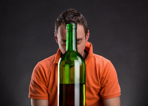 Adicto al alcohol mira la botella