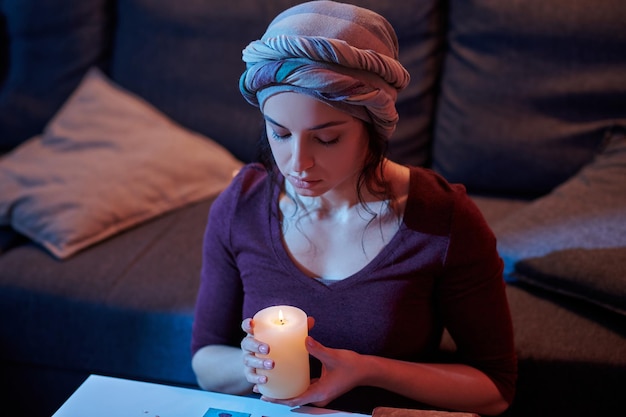 Adivino limpiando sus cartas del Tarot con velas