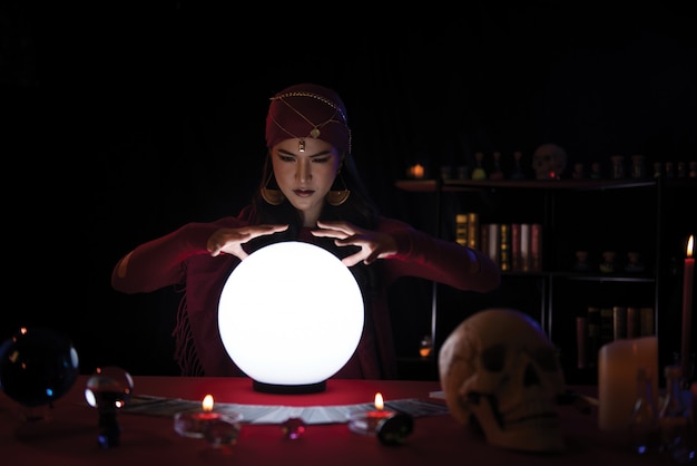 Adivino de mujer trabajando con bola de cristal con decoración. Retrato mujer adivino.