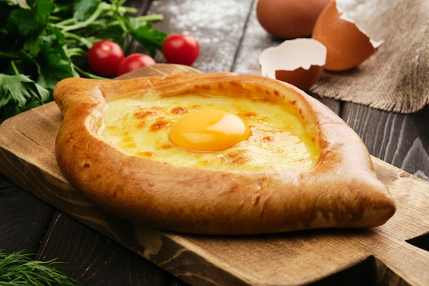 Adjarian khachapuri em tábua de servir de madeira com comida georgiana caucasiana