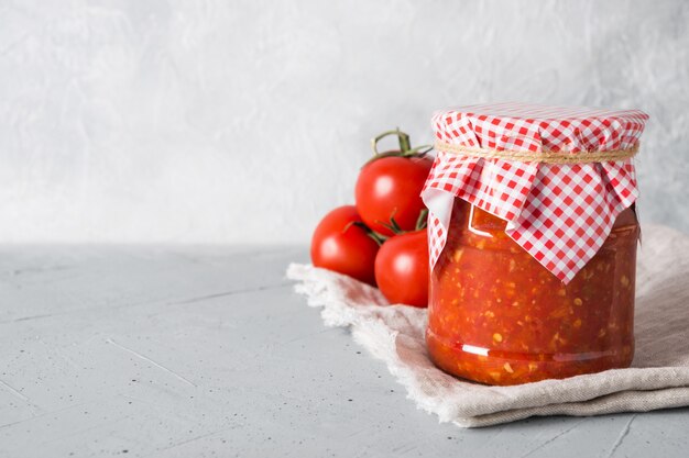Adjika de salsa de verduras con tomates, ajo, pimientos en tarro