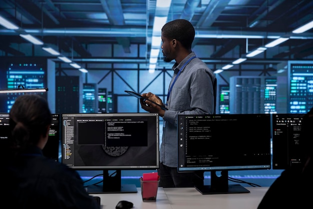 Administrador en el centro de datos utilizando la tableta para comprobar si hay problemas de rendimiento del servidor