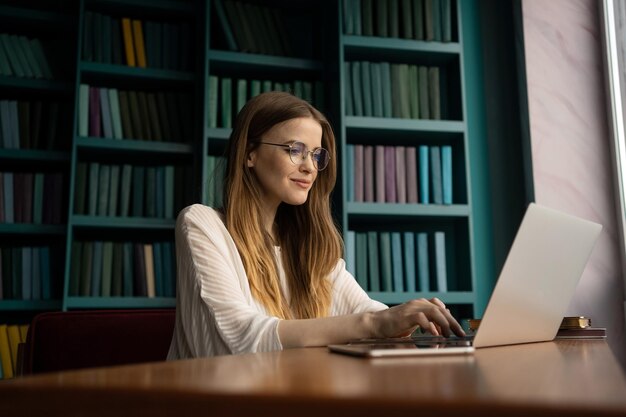 El administrador de videollamadas en el lugar de trabajo usa una computadora portátil Un estudiante con anteojos en la oficina de la biblioteca