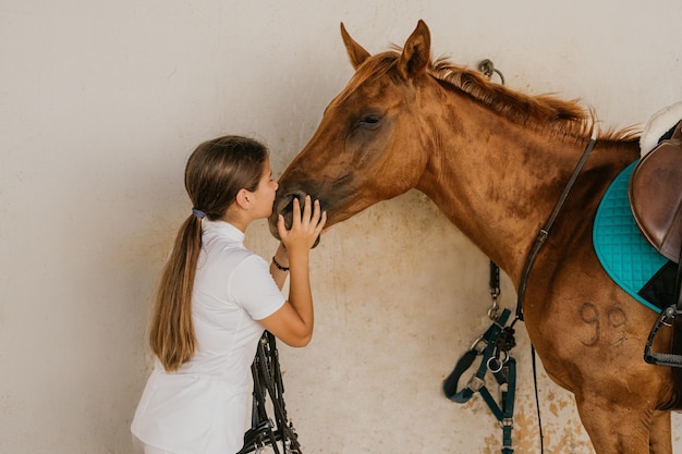 Adolescente de 15 años besando a un pony marrón en la nariz