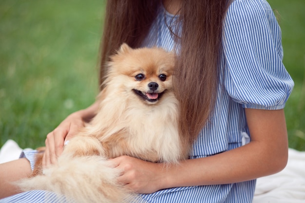 Adolescente abraçando cachorrinho em um parque ao ar livre