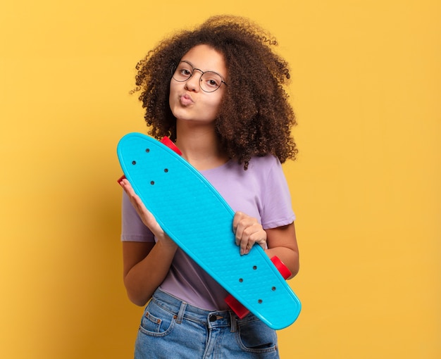 Adolescente afro com uma prancha de skate