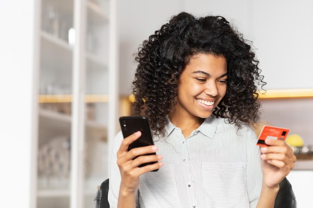 Adolescente afroamericana con una tarjeta de crédito