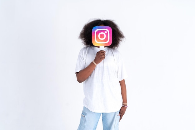 Adolescente afroamericano con una foto del logo de Instagram en sus manos