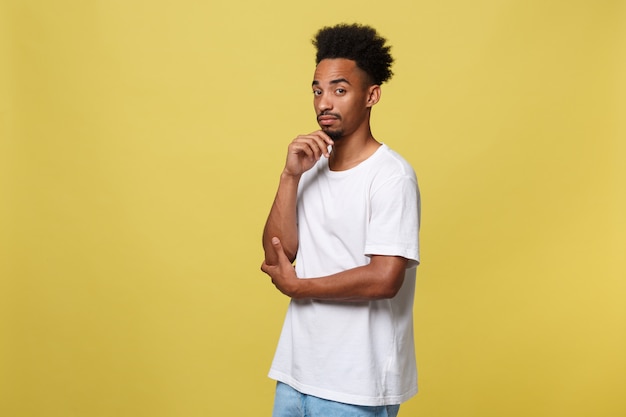 Adolescente afroamericano hermoso con el paño casual aislado en fondo amarillo.