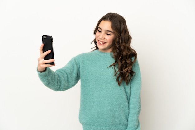 Adolescente aislado en la pared blanca haciendo un selfie