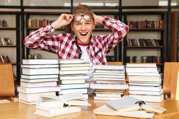 Adolescente alegre sentado na biblioteca