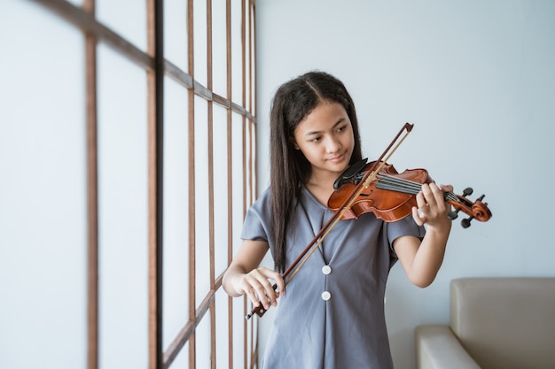 Adolescente aprende a tocar violino