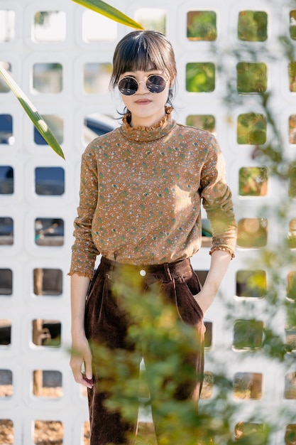 Adolescente asiática con gafas de sol redondas en vestido de estilo vintage retrato de modelo de colección de moda de verano