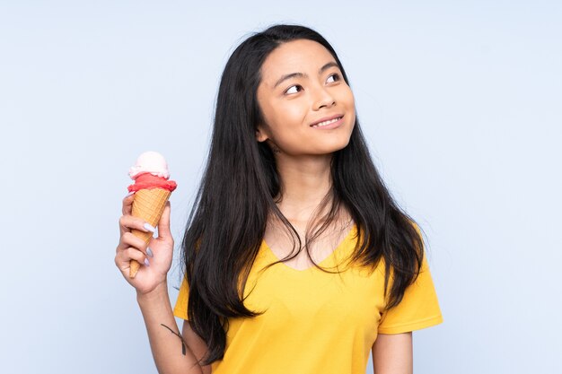 Adolescente asiática con un helado de cucurucho aislado