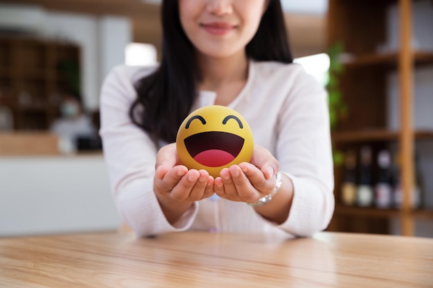 Adolescente asiático mostrando emoticono sonriente en las manos