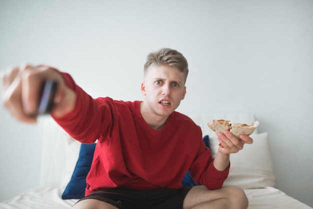 Adolescente assiste televisão e come pizza em casa, em uma sala aconchegante e luminosa