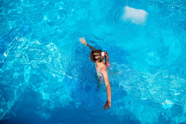 Una adolescente se baña en la piscina Vacaciones de verano