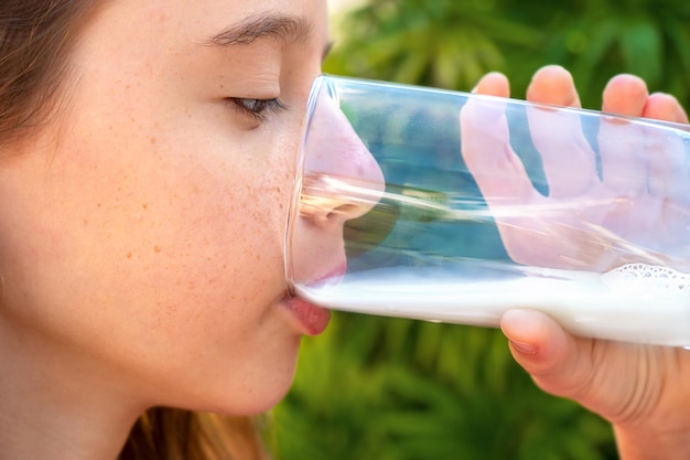 Adolescente bebiendo leche de un vaso al aire libre