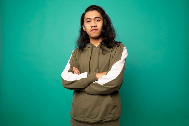 Adolescente bonito e sorridente com cabelo comprido em fundo verde