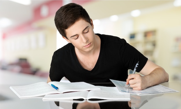 Adolescente bonito estudando sobre fundo desfocado