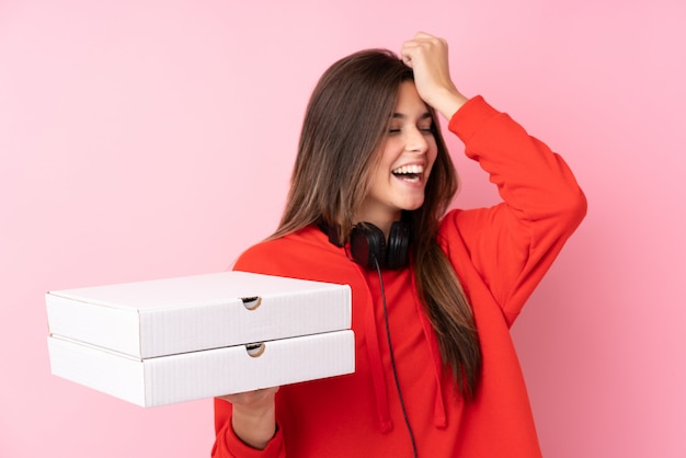 Adolescente brasileira segurando caixas de pizza sobre parede rosa isolada percebeu algo e pretendia a solução