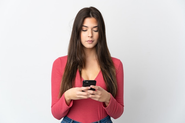 Adolescente brasileña aislada en blanco mediante teléfono móvil