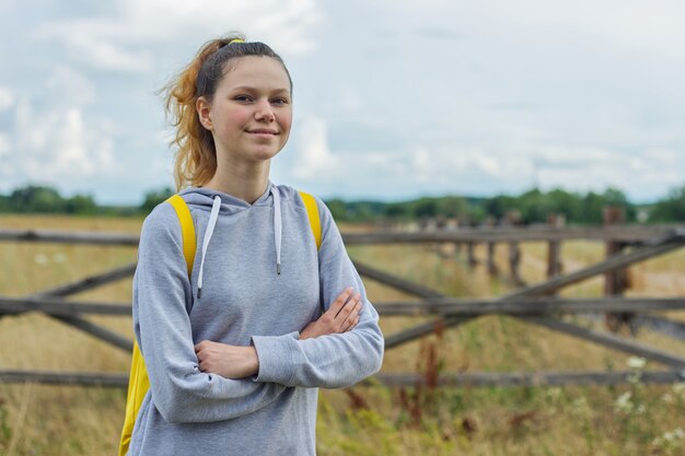 Adolescente con los brazos cruzados, niña en la naturaleza estilo rústico