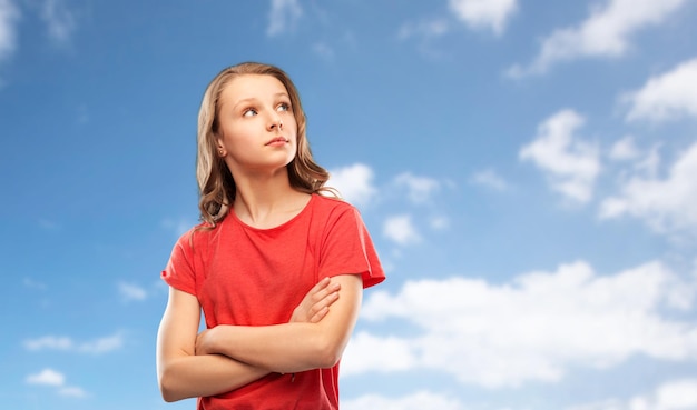 Foto una adolescente con los brazos cruzados sobre el cielo.