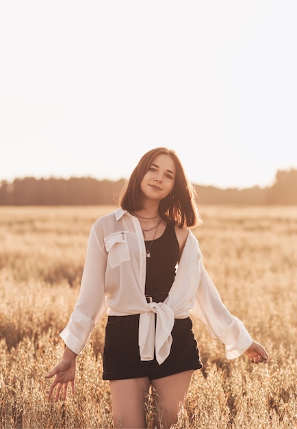 Adolescente camina sola en la naturaleza en verano. Colegiala con cabello negro relajante