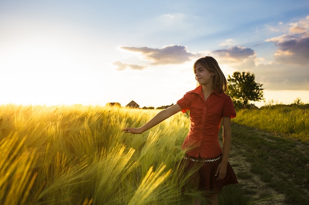 Foto adolescente en campo de trigo le gusta un cultivo