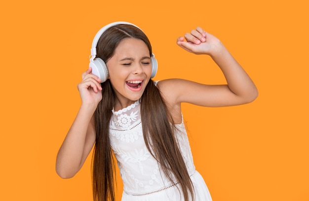 Un adolescente cantando escucha música con auriculares de fondo amarillo
