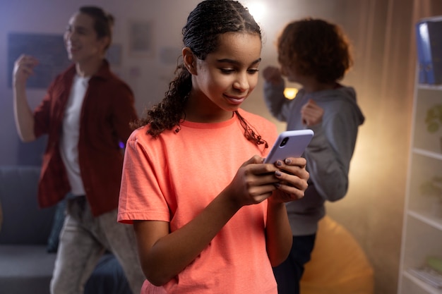 Foto adolescente en casa usando un teléfono inteligente durante la fiesta