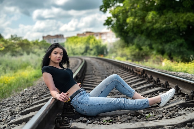 Adolescente caucasiano posando perto da ferrovia, liberdade