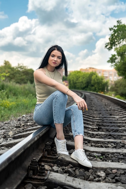 Adolescente caucasiano posando perto da ferrovia