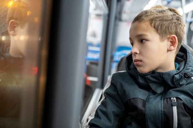 Adolescente con chaqueta viajando en autobús por la noche en la ciudad
