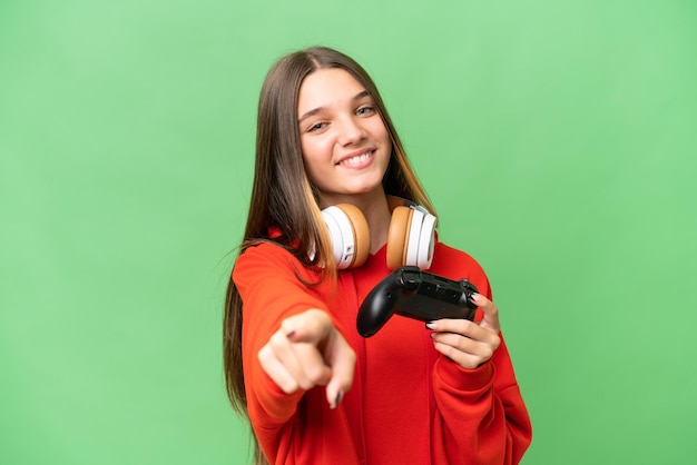 Adolescente chica caucásica jugando con un controlador de videojuegos sobre fondo aislado