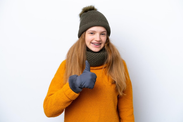 Adolescente chica rusa con chaqueta de invierno aislada de fondo blanco dando un gesto de pulgar hacia arriba