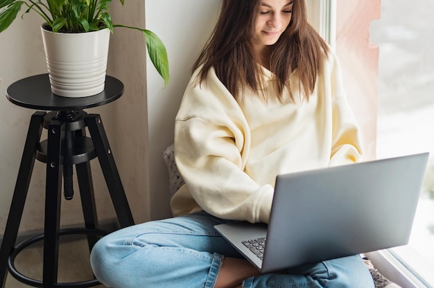 Adolescente colegiala alumna a distancia aprendiendo en línea en una clase virtual remota con un maestro por videoconferencia viendo una lección de reunión de zoom de seminario web en una computadora portátil en casa Enfoque selectivo suave