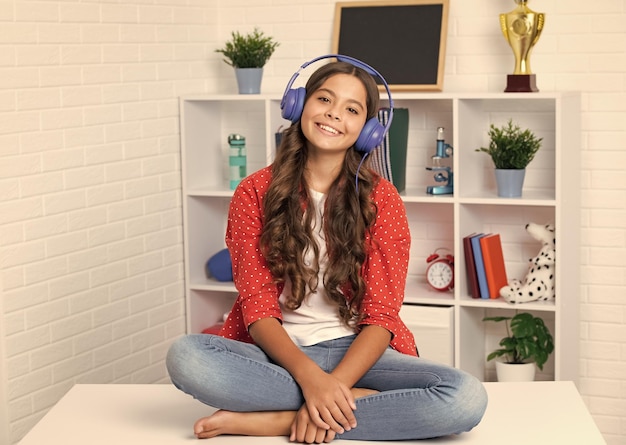 Adolescente colegiala escuchando música Retrato de adolescente con auriculares Concepto de emociones musicales para niños Niña de la escuela