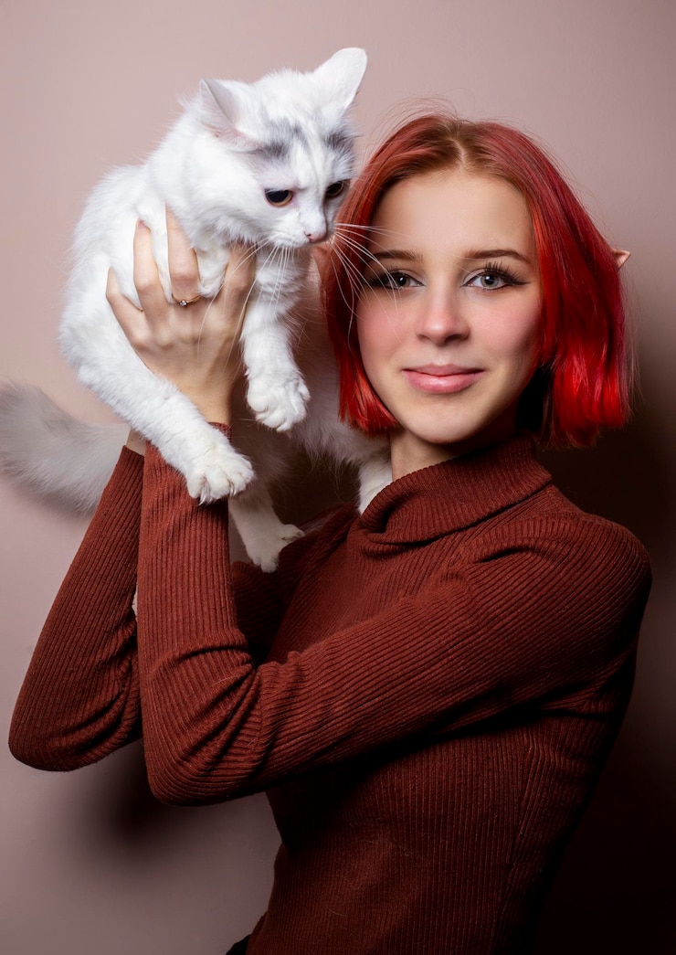 Foto adolescente com cabelo rosa segurando um gato branco em seus braços