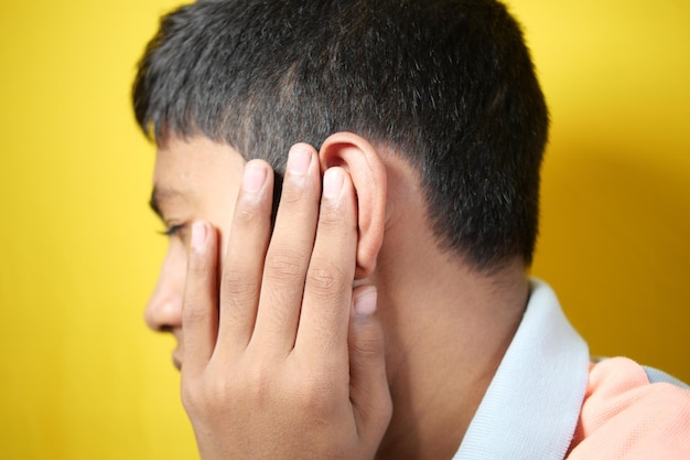 adolescente com dor de ouvido tocando sua orelha dolorosa