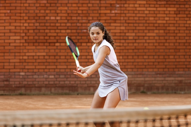 Adolescente com roupa esportiva jogando tênis