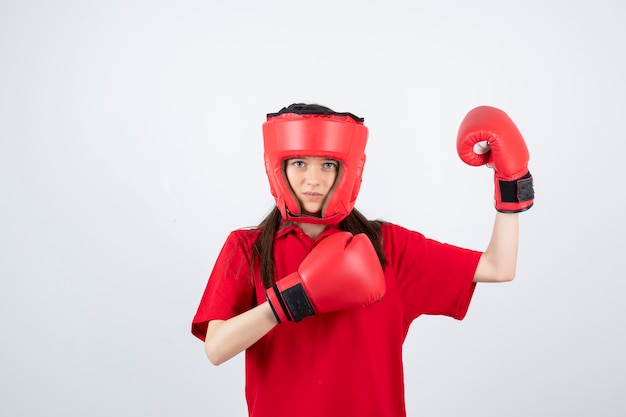 adolescente com uniforme vermelho e luva de boxe